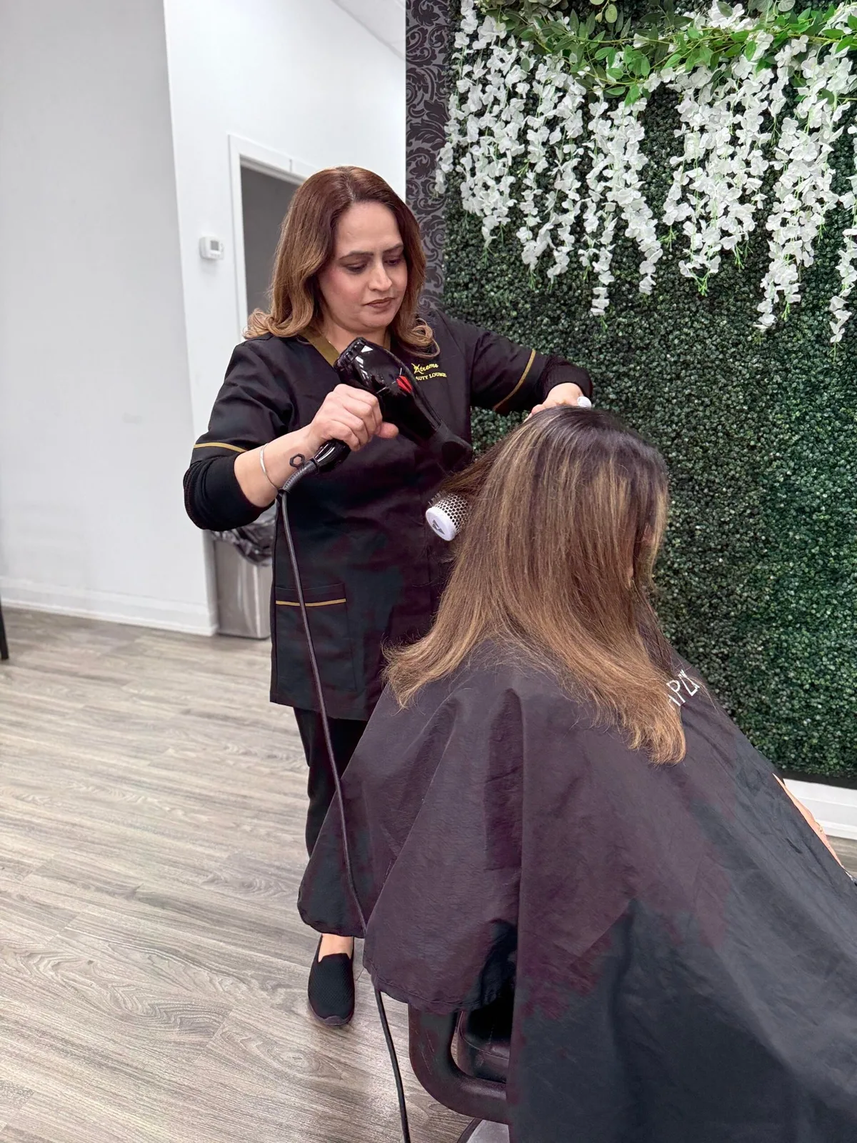 A stylist using a hairdryer and brush at the salon