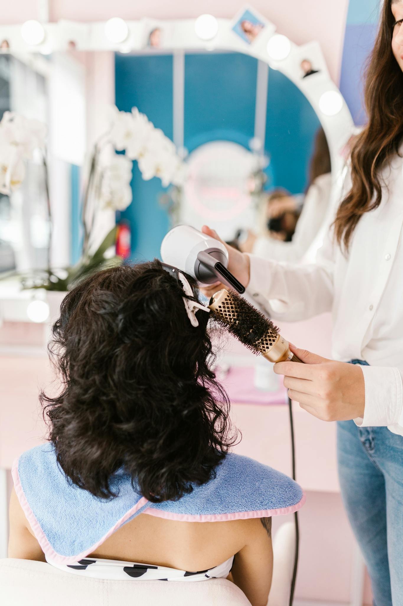 Woman receiving a hairstyle makeover in a vibrant salon setting.